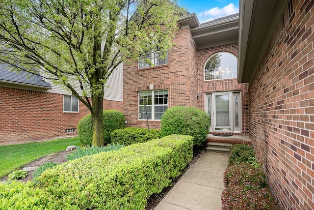 view of exterior entry featuring brick siding