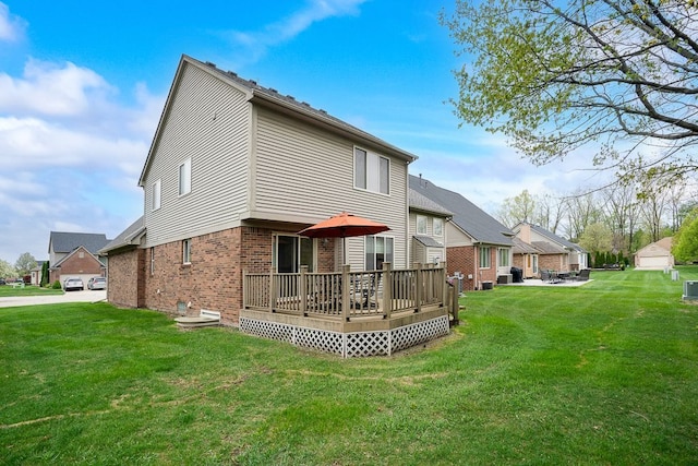 back of house featuring brick siding, a wooden deck, a lawn, and a residential view