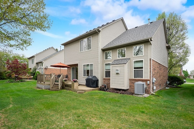 rear view of house with brick siding, central air condition unit, a yard, and a wooden deck