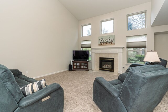 living area with high vaulted ceiling, light colored carpet, plenty of natural light, and a fireplace