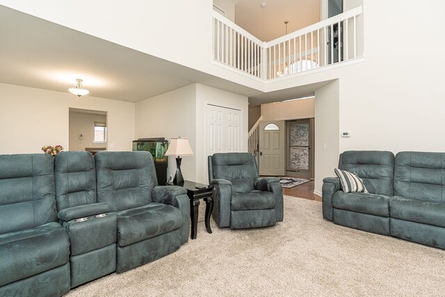 living room featuring carpet and a towering ceiling