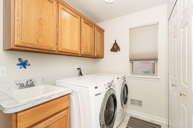 washroom with cabinet space and washer and dryer