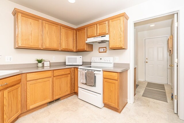 kitchen featuring white appliances, under cabinet range hood, light countertops, and recessed lighting