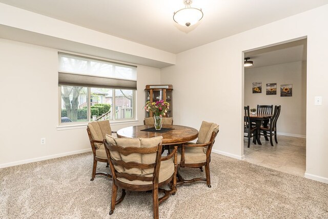 dining area with light colored carpet and baseboards