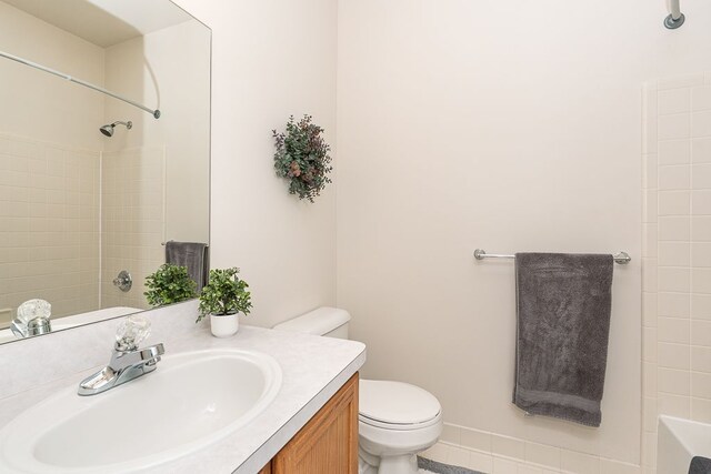 bathroom with toilet, vanity, and a shower