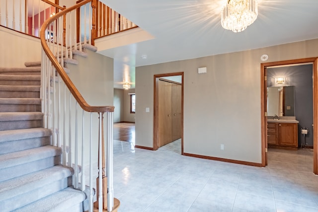 staircase featuring a chandelier, baseboards, and tile patterned flooring