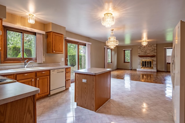 kitchen with dishwasher, a kitchen island, a sink, and light countertops