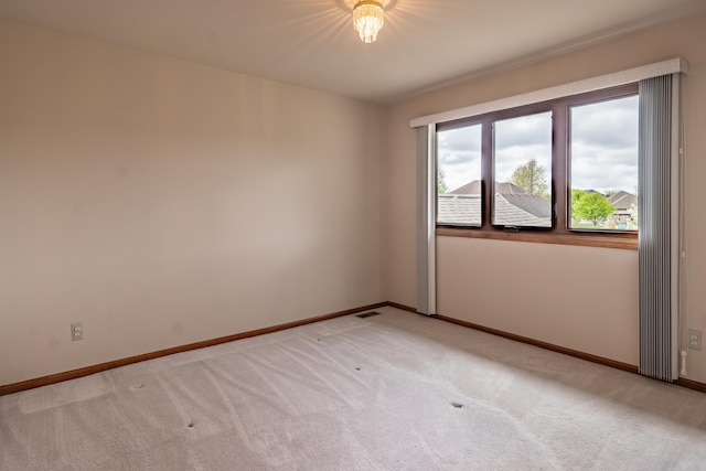 empty room with light colored carpet and baseboards