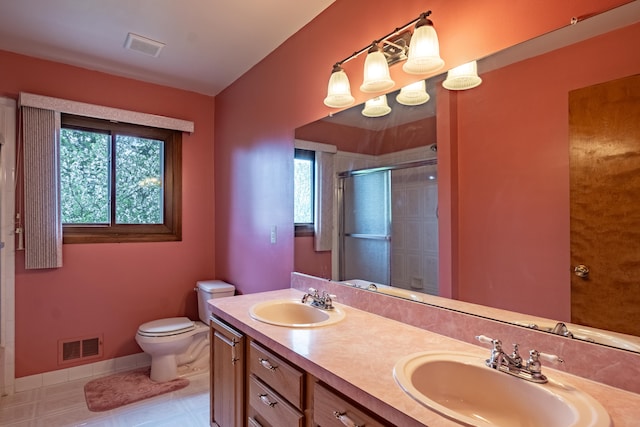 full bath with a stall shower, toilet, double vanity, and tile patterned floors