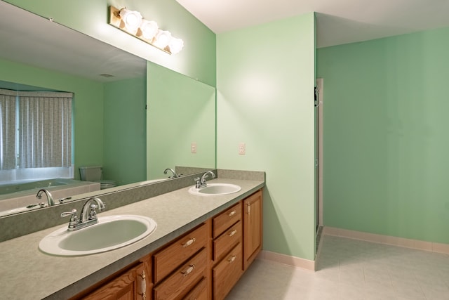 full bath featuring toilet, double vanity, baseboards, a bath, and tile patterned floors