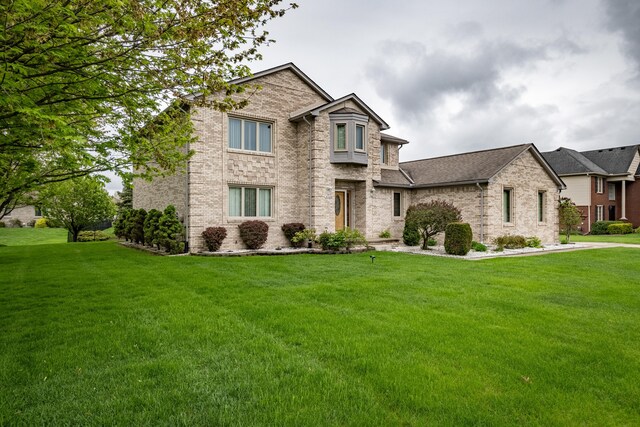 traditional-style house featuring a front yard and brick siding