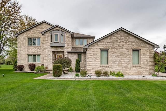 view of front of house featuring a front lawn and brick siding