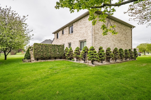 view of property exterior featuring a lawn and brick siding