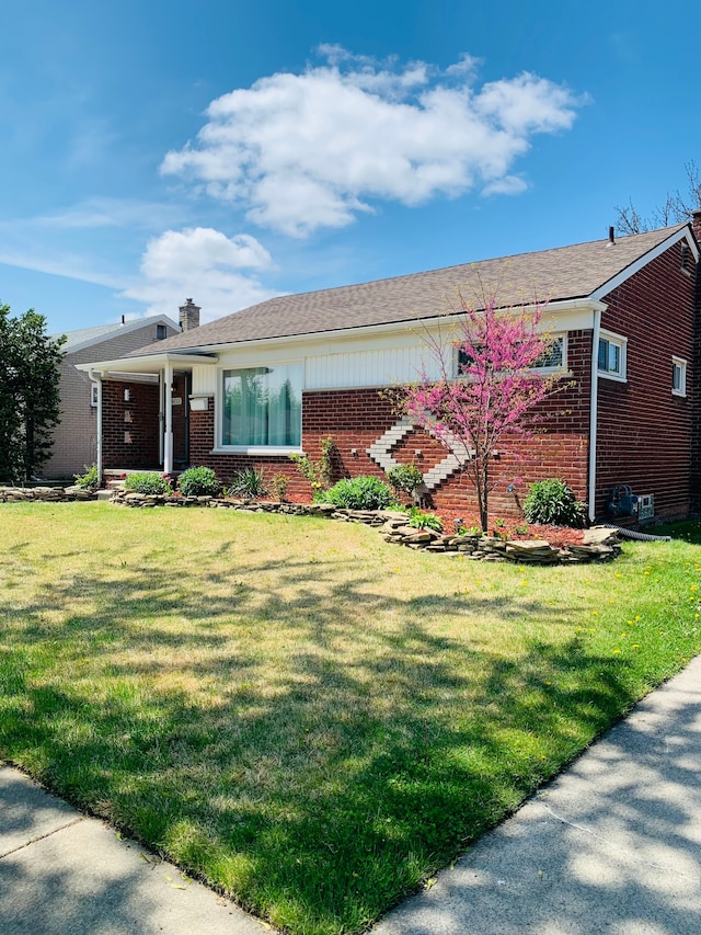 ranch-style house featuring brick siding, a front lawn, and a chimney