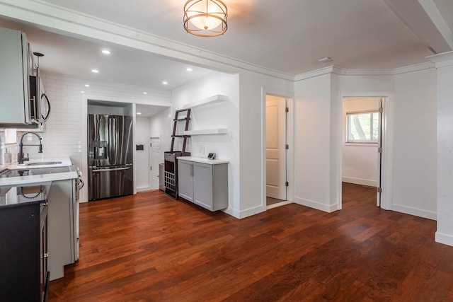 kitchen with appliances with stainless steel finishes, a sink, light countertops, dark wood-style floors, and recessed lighting