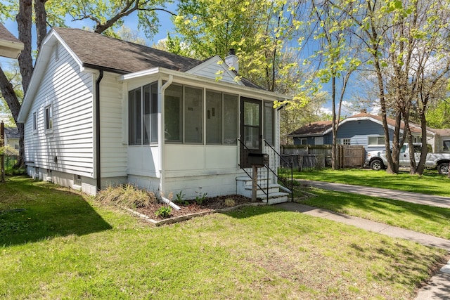 bungalow-style house with a sunroom, a chimney, a shingled roof, and entry steps