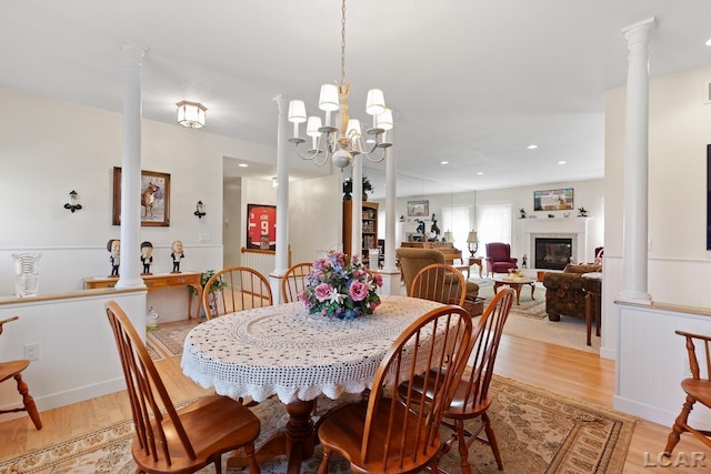 5225 Bent Oak Hwy, Adrian, MI 49221 - dining area featuring an inviting chandelier, ornate columns, a glass covered fireplace, light wood-style floors, and recessed lighting