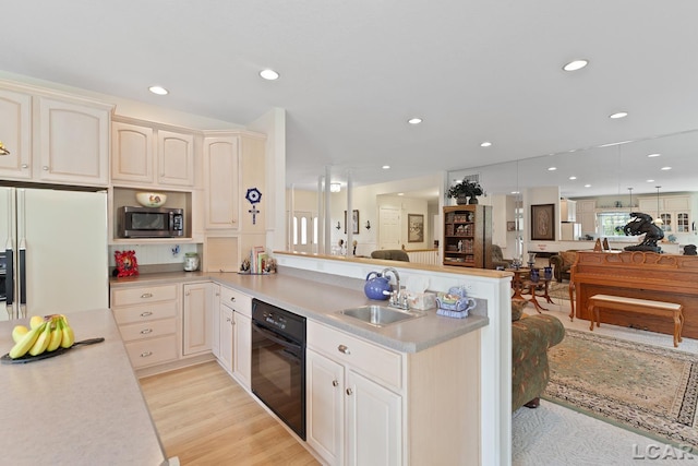 5225 Bent Oak Hwy, Adrian, MI 49221 - kitchen featuring a sink, black oven, open floor plan, and white fridge with ice dispenser