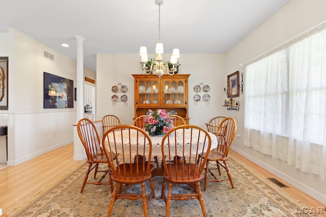 5225 Bent Oak Hwy, Adrian, MI 49221 - dining room featuring light wood finished floors, a chandelier, visible vents, and ornate columns