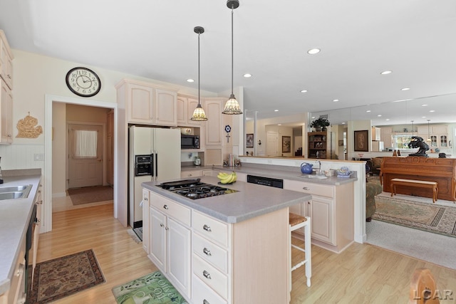 5225 Bent Oak Hwy, Adrian, MI 49221 - kitchen featuring a sink, a kitchen breakfast bar, black appliances, light wood-style flooring, and open floor plan