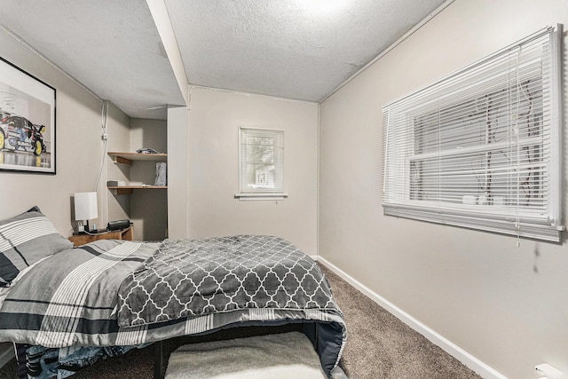 bedroom with a textured ceiling, carpet, and baseboards