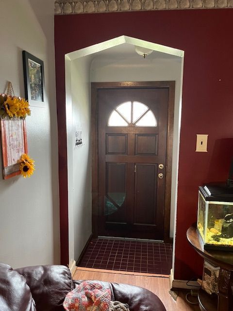 doorway to outside with wood finished floors and baseboards