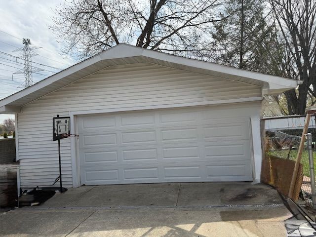 detached garage featuring fence