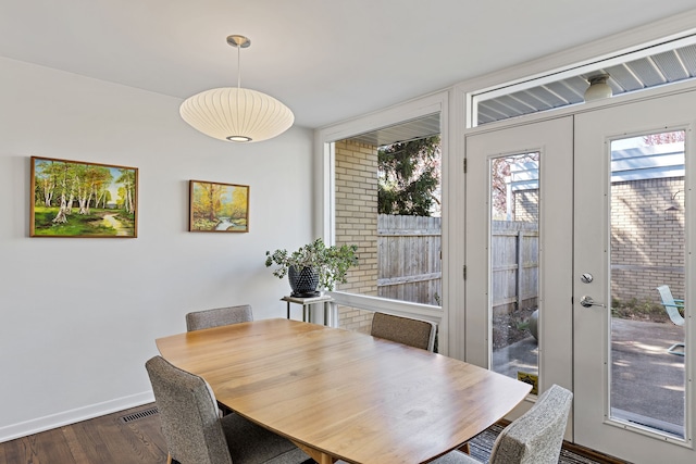 dining room with dark wood-type flooring and baseboards