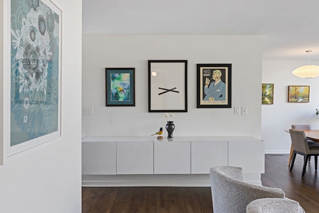 interior space featuring hanging light fixtures, baseboards, and dark wood-style floors