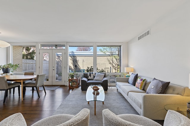 living room featuring floor to ceiling windows, wood finished floors, visible vents, and french doors