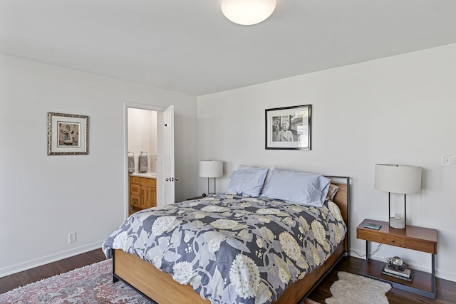 bedroom featuring wood finished floors, baseboards, and ensuite bathroom