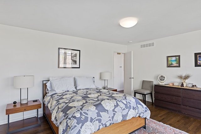 bedroom featuring baseboards, visible vents, and dark wood finished floors