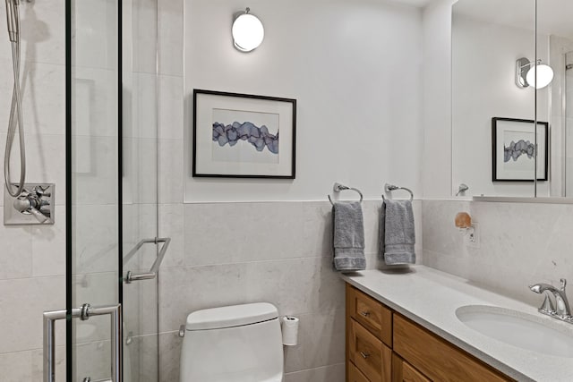 full bathroom featuring a stall shower, tile walls, vanity, and toilet