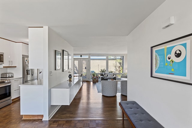interior space featuring open floor plan, white cabinetry, modern cabinets, light countertops, and appliances with stainless steel finishes
