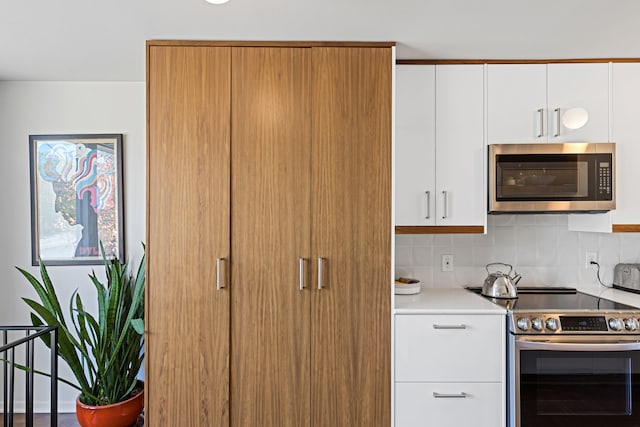 kitchen featuring light countertops, white cabinetry, stainless steel appliances, and tasteful backsplash