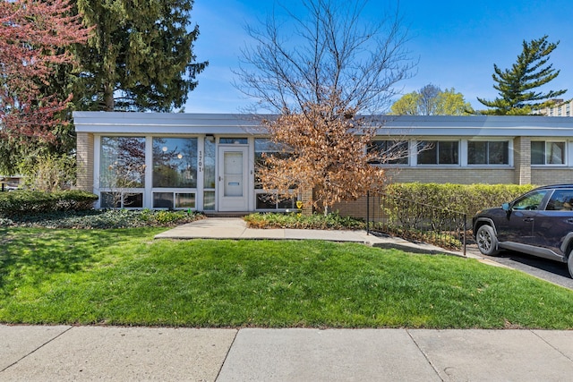 view of front of house with brick siding and a front lawn