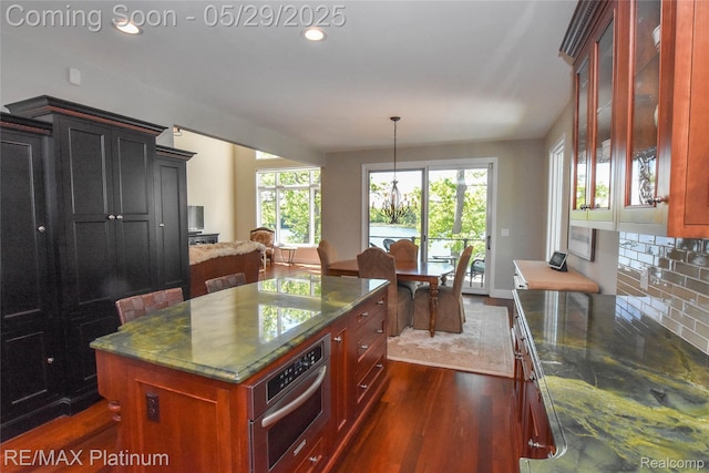 841 Hurley Dr, Howell, MI 48843 - kitchen featuring oven, dark wood finished floors, a kitchen island, recessed lighting, and dark stone countertops