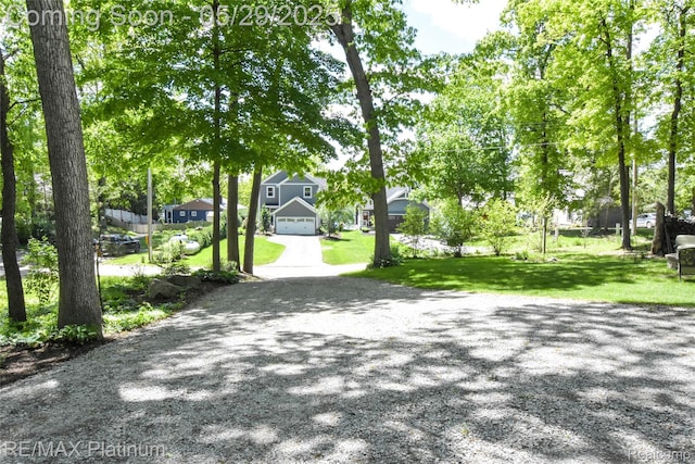 841 Hurley Dr, Howell, MI 48843 - view of community featuring asphalt driveway, a lawn, and a garage