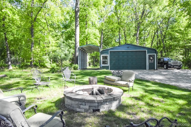 841 Hurley Dr, Howell, MI 48843 - view of grassy yard with a fire pit, an outdoor structure, and a detached garage