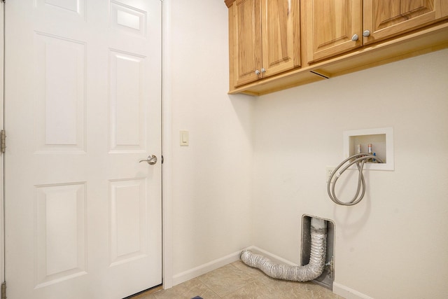 washroom featuring baseboards, washer hookup, and cabinet space