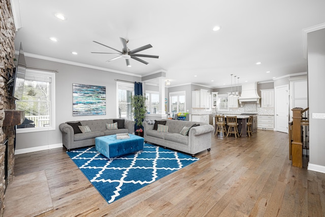 living room featuring recessed lighting, baseboards, ceiling fan, crown molding, and wood finished floors