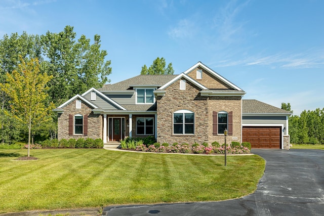 craftsman-style house featuring a front yard, aphalt driveway, a garage, and stone siding