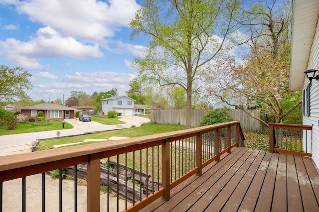 wooden deck featuring fence, a residential view, and a lawn