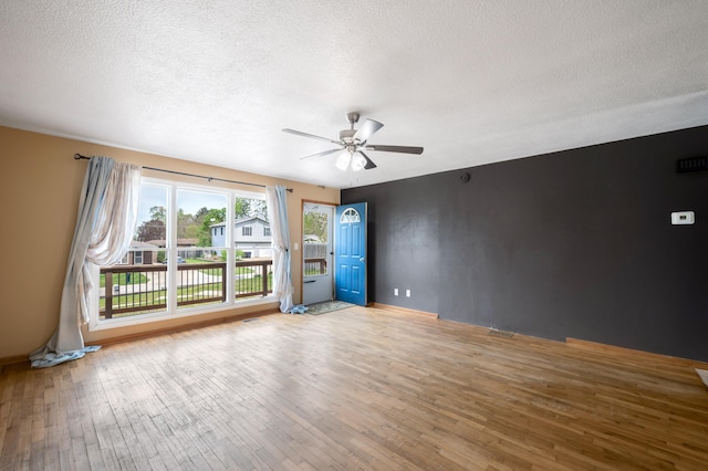spare room with ceiling fan, a textured ceiling, and hardwood / wood-style floors