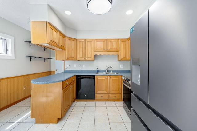 kitchen featuring a sink, wainscoting, light tile patterned flooring, and appliances with stainless steel finishes