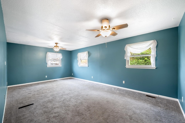 spare room with a textured ceiling, baseboards, ceiling fan, and carpet floors