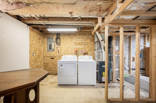 washroom featuring laundry area, washer and dryer, heating unit, and electric panel