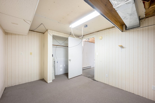 finished below grade area featuring carpet, baseboard heating, and wallpapered walls