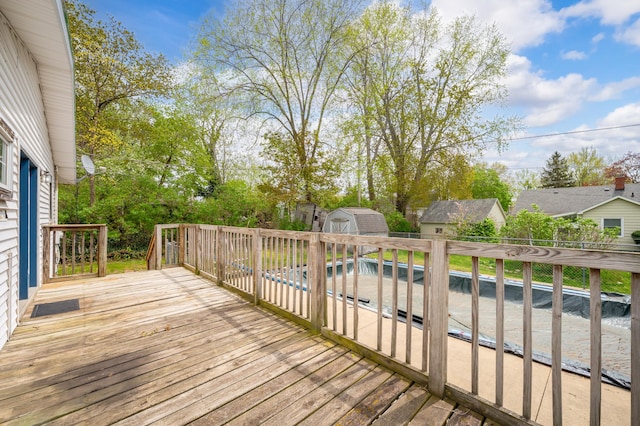 wooden deck featuring an outdoor structure and a storage shed