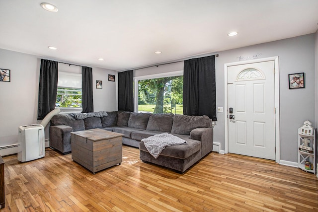 living area with a wealth of natural light, light wood-style flooring, and recessed lighting